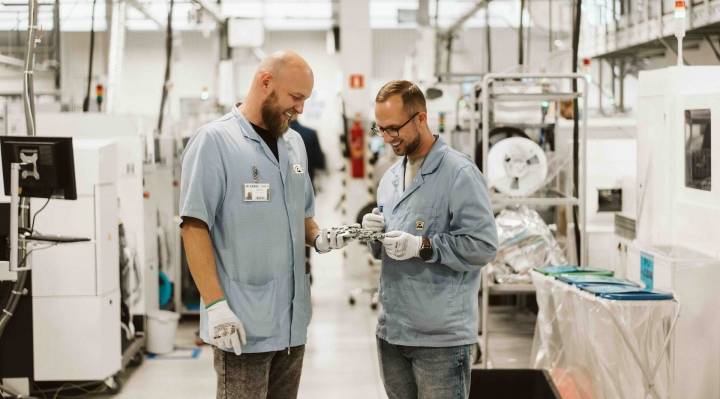Dwaj inżynierowie ASSEL oglądają zmontowaną płytkę PCBA na hali produkcyjnej